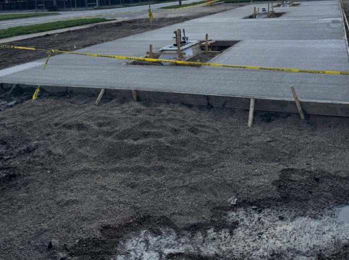Large commercial concrete slab poured and screeded on a site behind safety tape
