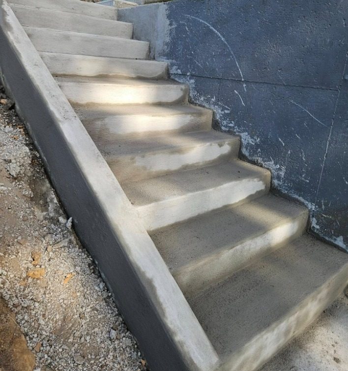 Finished flight of concrete stairs against a formed retaining wall